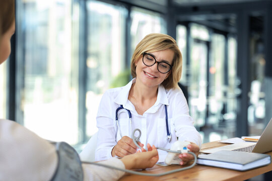Middle aged female doctor therapist in consultation with patient in office.