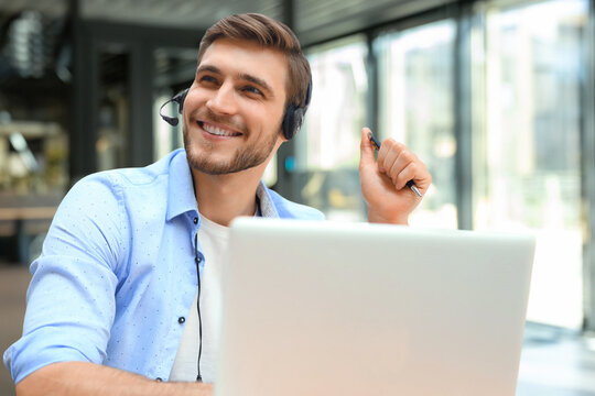 Smiling friendly handsome young male call centre operator.