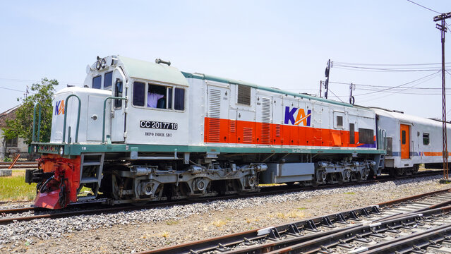 CC 201 77 16 diesel locomotive train of PT KAI stopped at Gundih railway station in Grobogan Central Java Indonesia. Classic public transport engine on railroad track under bright sunny sky.