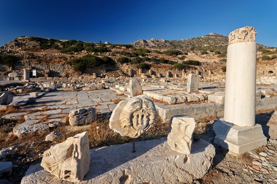 View of Knidos Ancient City with scattered marble ruins, stone columns, and fragments of ancient sculptures under a clear blue sky in Datca, Mugla, Turkey.