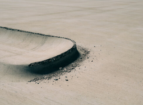 Close-up view of a shallow concrete spall with a cavity on a broad slab