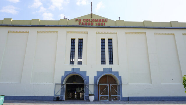 Front exterior view of historic De Tjolomadoe sugar mill heritage site built in 1861 with Dutch colonial architecture, arch doors, and yellow facade wall in Karanganyar, Central Java, Indonesia.