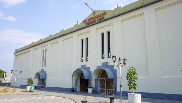 Front exterior view of historic De Tjolomadoe sugar mill heritage site built in 1861 with Dutch colonial architecture, arch doors, and yellow facade wall in Karanganyar, Central Java, Indonesia.