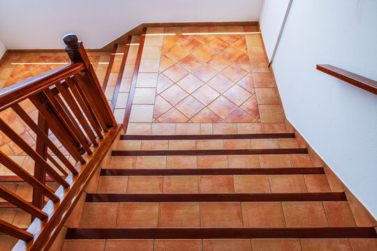 Close-up view of tiled staircase with wooden railings and square landing inside building.  Gran Canaria. Spain. 