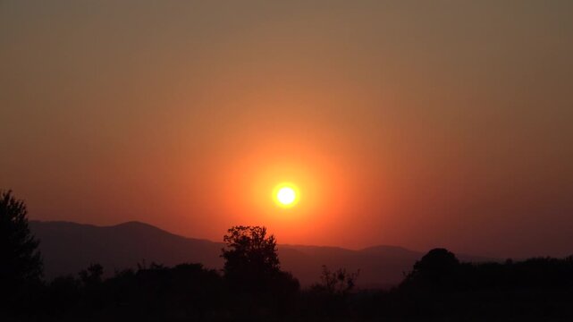 Dramatic Sunset Sun Over Mountain Horizon Silhouette.Epic Sunset Over Silhouetted Mountain Peaks at Dusk
