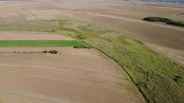 Panoramic Drone Shot Over Summer Farmland. Stunning Drone Aerial of Cultivated Fields and Green Vegetation.