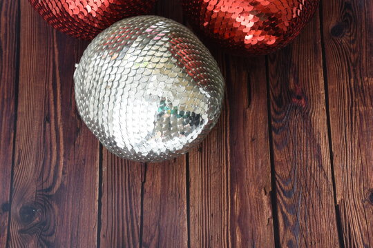 Top view of red and silver sequin Christmas baubles with sparkling glitter details, festive holiday decorations, elegant seasonal background, and shimmering metallic textures.