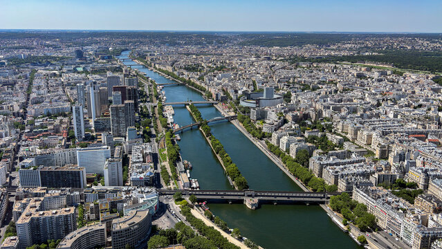 View of the Seine River winding through the urban landscape with historic buildings, bridges, and dense city architecture in Paris, Ile-de-France, France.