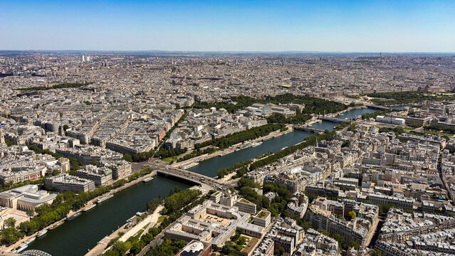 View of the Seine River winding through the dense historic urban architecture and bridges of Paris, Ile-de-France, France.