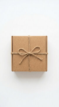 Minimalist Brown Cardboard Gift Box Tied with Natural Twine Bow on White Background Top View