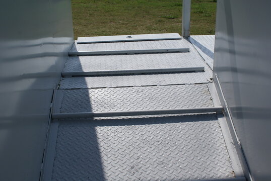 Diamond plate steel ramp floor with cleats inside a livestock chute