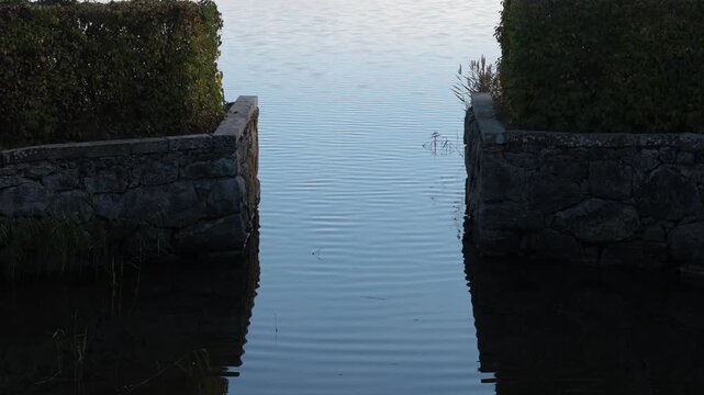 Nykoping, Sweden Small ripples of Baltic Sea water slide into an old stone enclosure on the seashore.   
