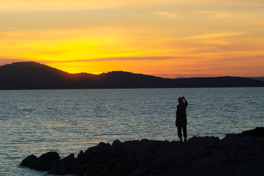Silhouette of Person Photographing Sunset over the Adriatic Sea in Zadar, Croatia