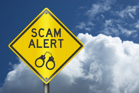 Scam Alert yellow warning sign with sky