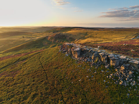 Beautiful drone landscape image view over Burbage South Edge in Peak District during Summer heather sunset