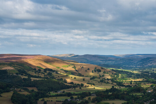 Stunning Peak District landscape from Surprise View with vibrant heather and dappled sunlight over the hills