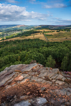 Stunning Peak District landscape from Surprise View with vibrant heather and dappled sunlight over the hills