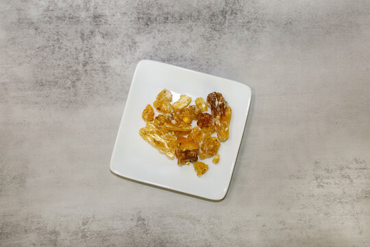 Frankincense resin tears on a small white square plate.