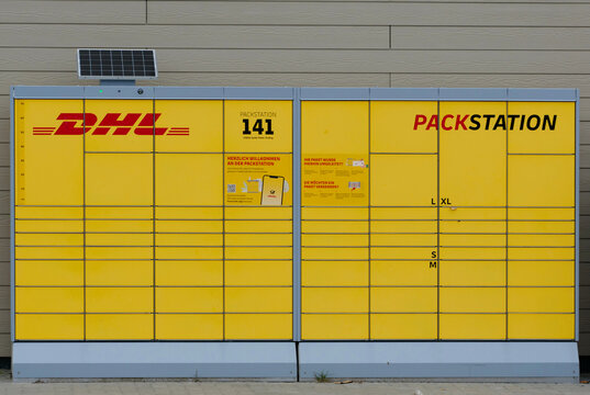 Germany, St. Peter Ording, October 18. 2026, A yellow DHL Packstation automatic parcel locker station with a little solar panel on top