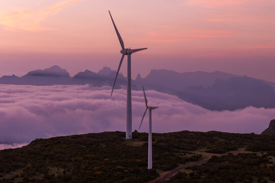 Wind turbines on elevated terrain above cloud cover in Madeira, decarbonization and energy transition concept