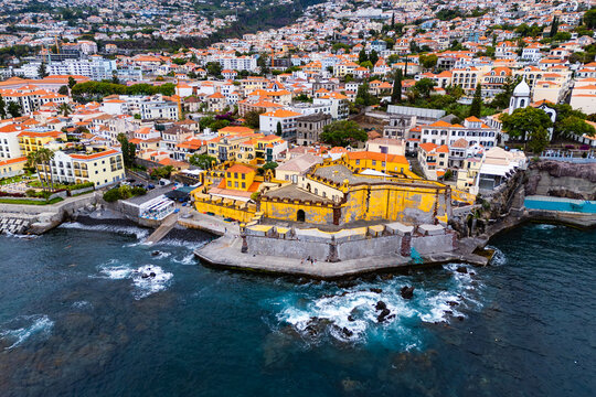 Historic yellow fortress Sao Tiago at the waterfront of Funchal city, Madeira Island, aerial view