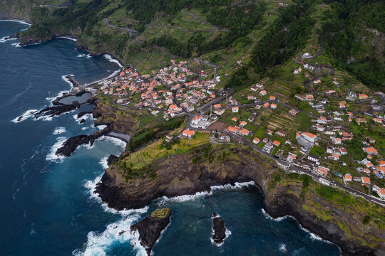 Seixal and rugged north coast of Madeira, Portugal, aerial view. Coastal village beside Atlantic bays and steep mountain slopes