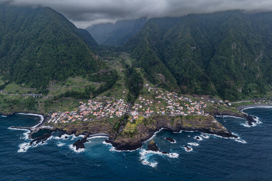 Seixal coastal village in Madeira, Portugal, wide aerial view. Mountain valley settlement and volcanic Atlantic shoreline