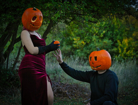 Scenes of a young couple with Halloween pumpkins on their heads
