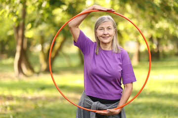 Senior woman with hula hoop in park © New Africa