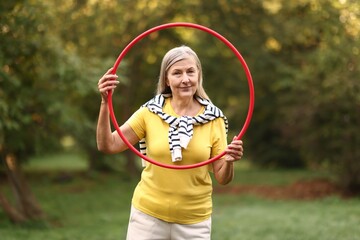 Senior woman with hula hoop in park © New Africa