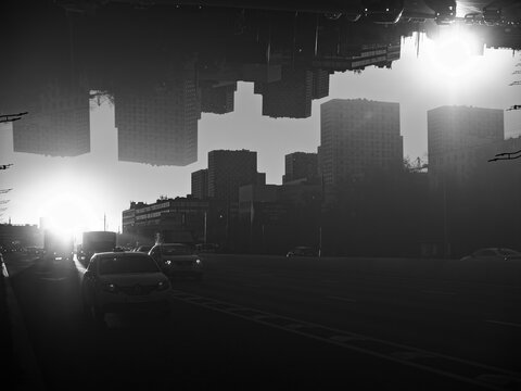 Surreal cityscape with inverted skyscrapers and sunset city traffic