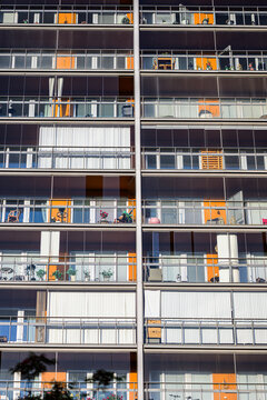 Modern apartment building facade with stacked glazed balconies.