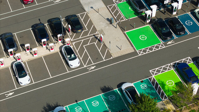 Aerial view of electric vehicle charging stations with parked cars in a parking lot in Rugby, England, United Kingdom.