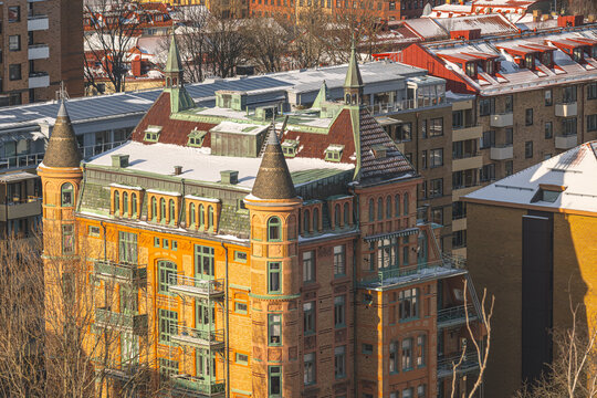 Historic ornate brick building with towers in urban winter setting.
