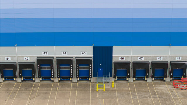 Aerial view of a large distribution center with numbered loading bays and a concrete yard in Magna Park, England, United Kingdom.