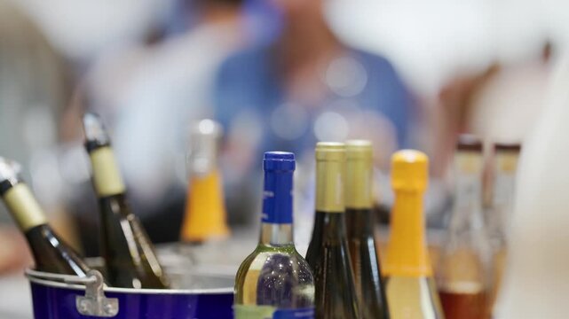 Wine bottles cooling in a blue ice bucket during a party