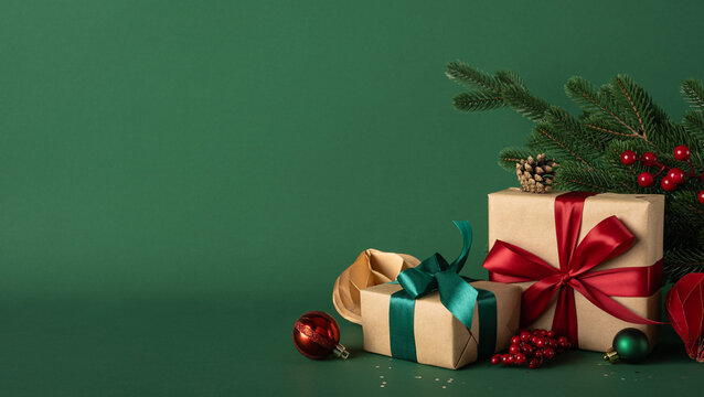 Merry Christmas and happy New Year with wrapped presents and festive decorations on green side view background