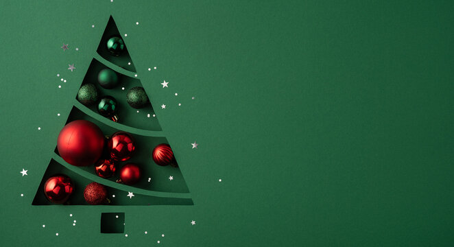 Merry Christmas and happy New Year green paper cutout tree with red ornament and confetti on bright green poster with blank space for congrats