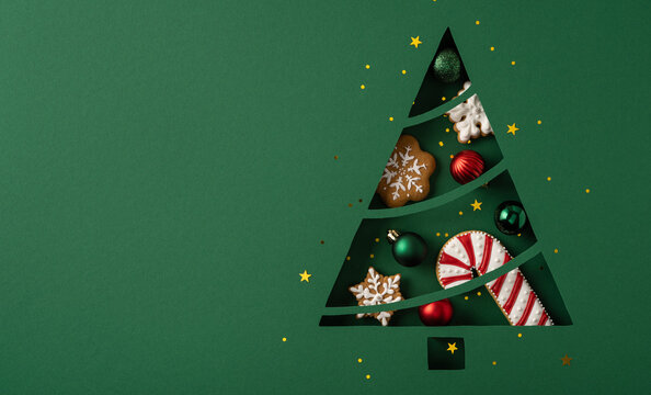 Merry Christmas creative vision with paper-cut tree, ornaments, gingerbread and candy for Happy New Year greeting on wide placard banner for advertising