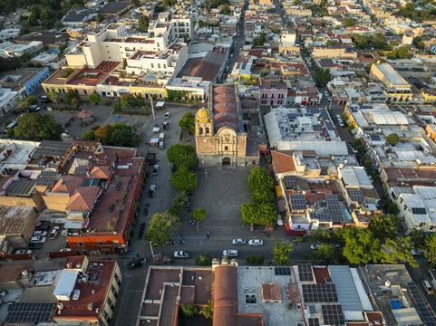 Aerial view of Parroquia Santiago Apostol in the town square surrounded by historic buildings, rooftops, and lush trees in Tequila, Jalisco, Mexico.