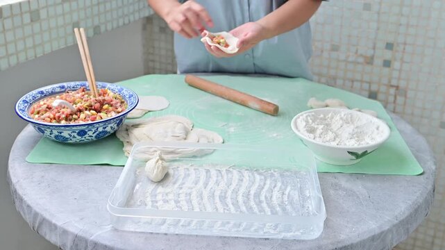 Housewife making dumplings by hand at home