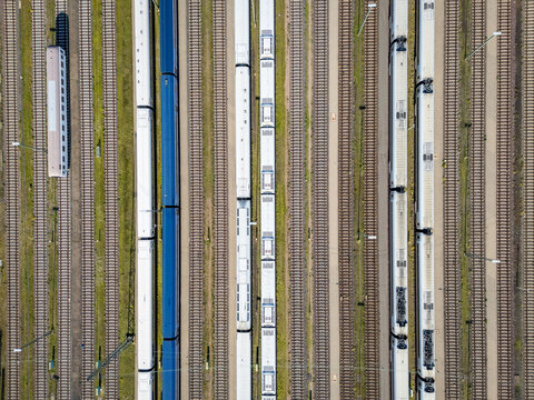 Aerial view of train tracks with multiple passenger trains parked on parallel lines in a railway depot in Germany.