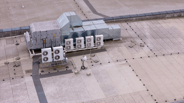 Aerial view of an industrial HVAC system with ventilation ducts and multiple air conditioning units installed on a flat concrete rooftop in Gdansk, Polska.