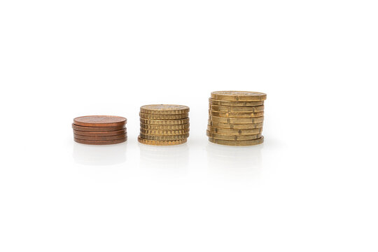 Stacks of coins arranged by size on a white surface