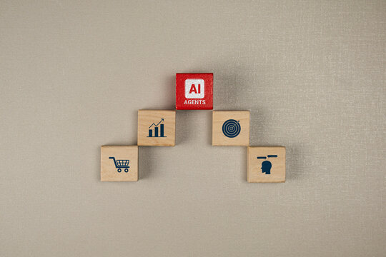 Business innovation with AI agents. Stacked wooden blocks, featuring icons related to technology and business, represent automation. Top-down view.