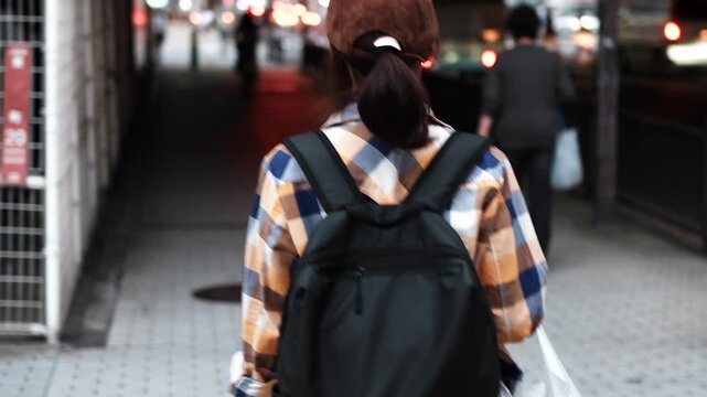 Woman Walking Through City Street at Dusk Rear View Slow Motion