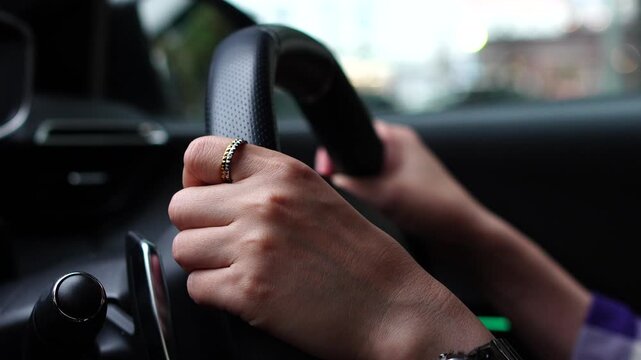 Close-up of a Driver's Hands Holding the Steering Wheel while Driving