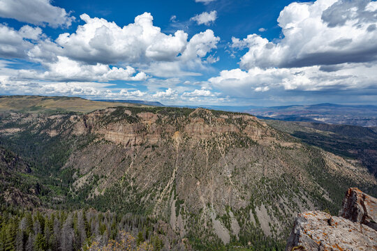 Elevated view of Deep Creek and surrounding mountains from Deep Creek Overlook in Colorado Flat Tops Wilderness under sunny summer cloudscape.