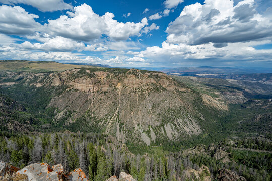 Elevated view of Deep Creek and surrounding mountains from Deep Creek Overlook in Colorado Flat Tops Wilderness under sunny summer cloudscape.