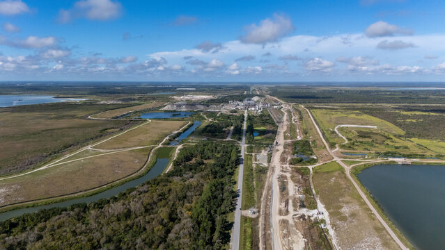 Aerial view of the Four Corners Mine, a large phosphate mining facility with industrial buildings, settling ponds, and surrounding wetlands in Duette, Florida, United States.